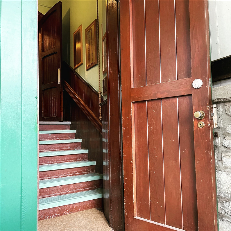 brown, wooden, church door open. stairs up