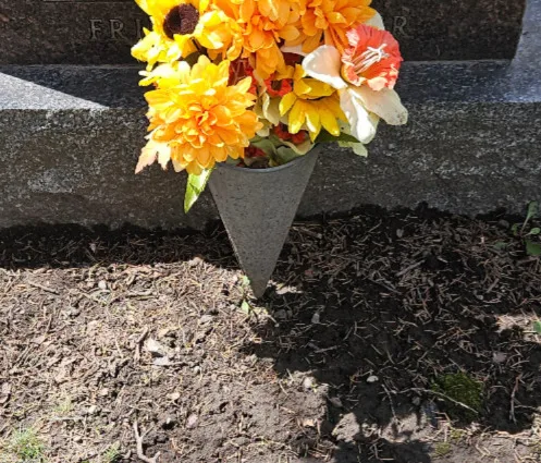 grey metal cone-shaped vase with a metal spike at the bottom